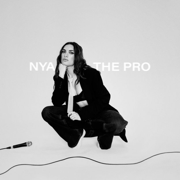 Contemplative person squatting with microphone nearby.